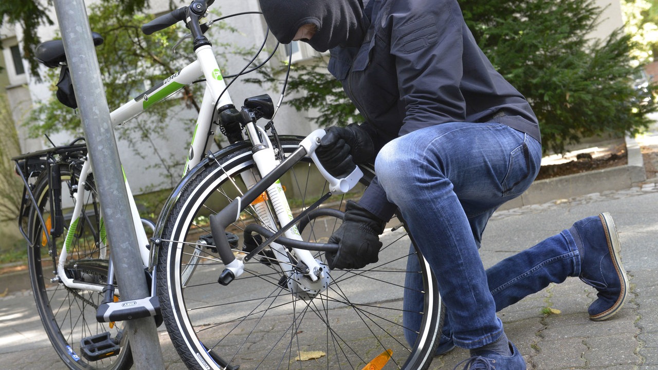 Ein Dieb versucht mit einer Säge ein Fahrradschloss zu knacken (Symbolbild)