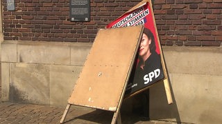 Es ist ein zerstörtes Plakat einer Angeordneten zur Europawahl zu sehen.