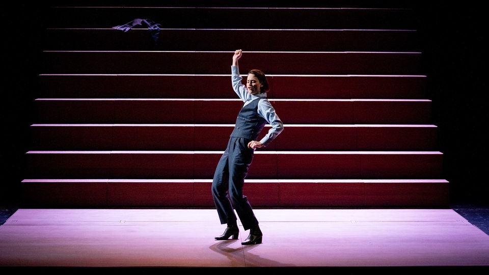 Eine Frau tanzt auf der Bühne vor einer Treppe